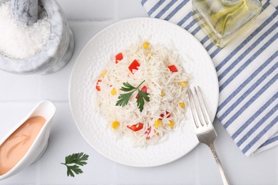 Photo of Delicious rice with vegetables and parsley served on white table, flat lay