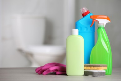 Cleaning supplies on table in bathroom, space for text