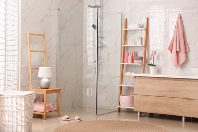 Photo of Modern bathroom interior with decorative ladder and shower stall