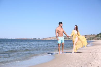 Photo of Woman in bikini and her boyfriend on beach, space for text. Happy couple