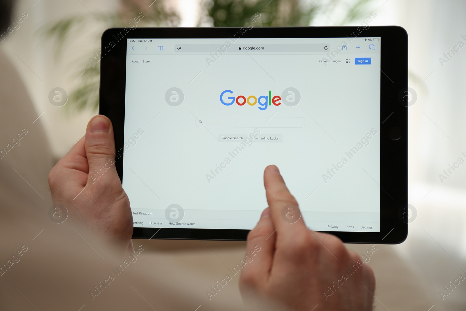 Photo of MYKOLAIV, UKRAINE - OCTOBER 27, 2020: Man using Google search engine on tablet against blurred background, closeup