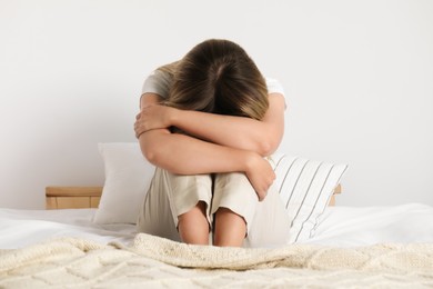 Photo of Sleepless woman sitting on bed at home