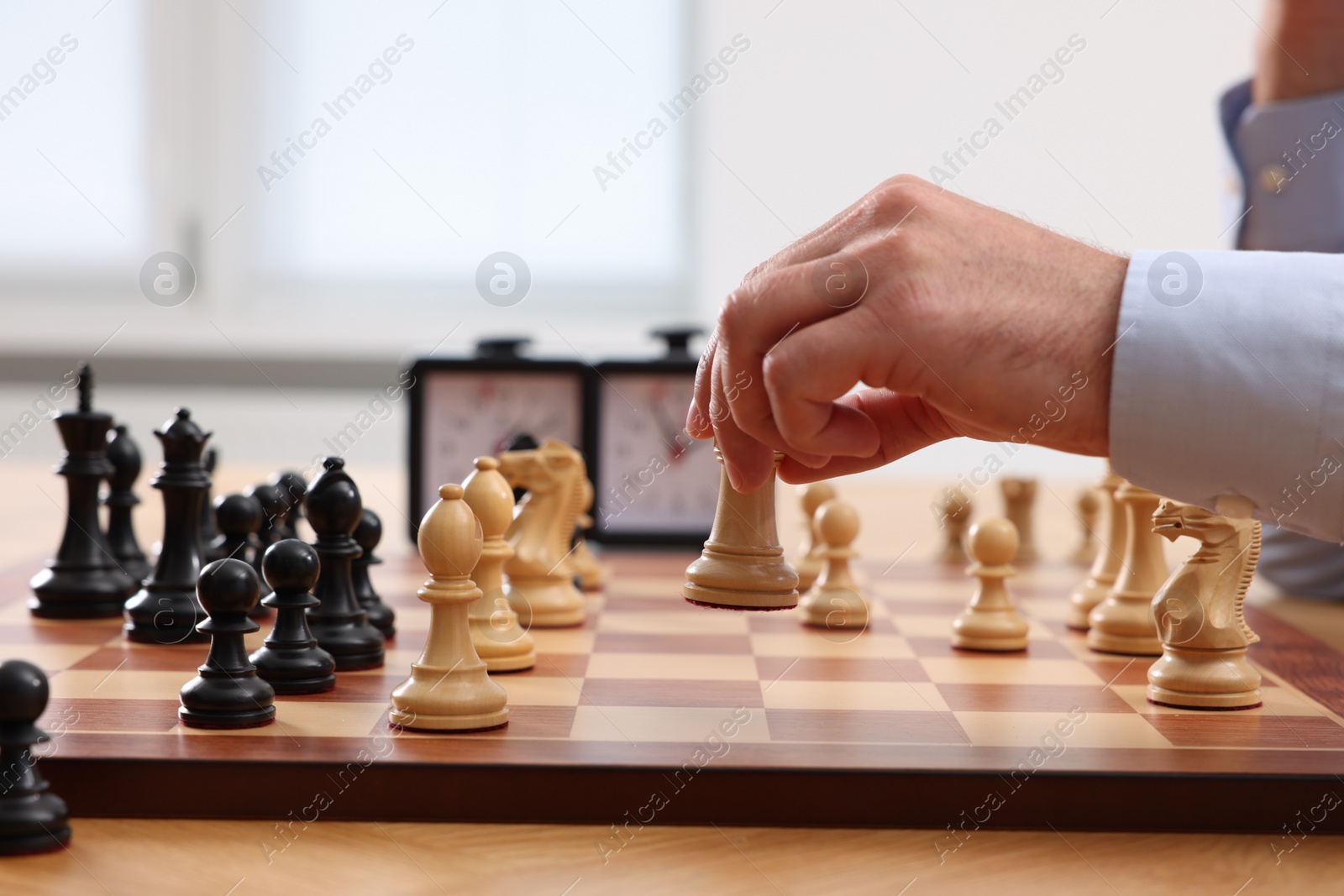 Photo of Man playing chess during tournament at table, closeup