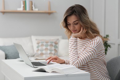 Photo of Online test. Woman studying with laptop at home