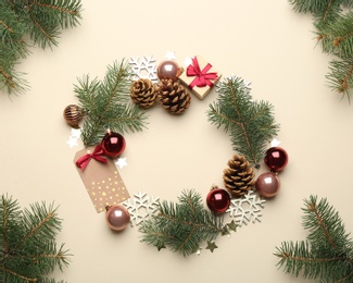 Frame made of Christmas decorations on beige background, top view with space for text. Winter season