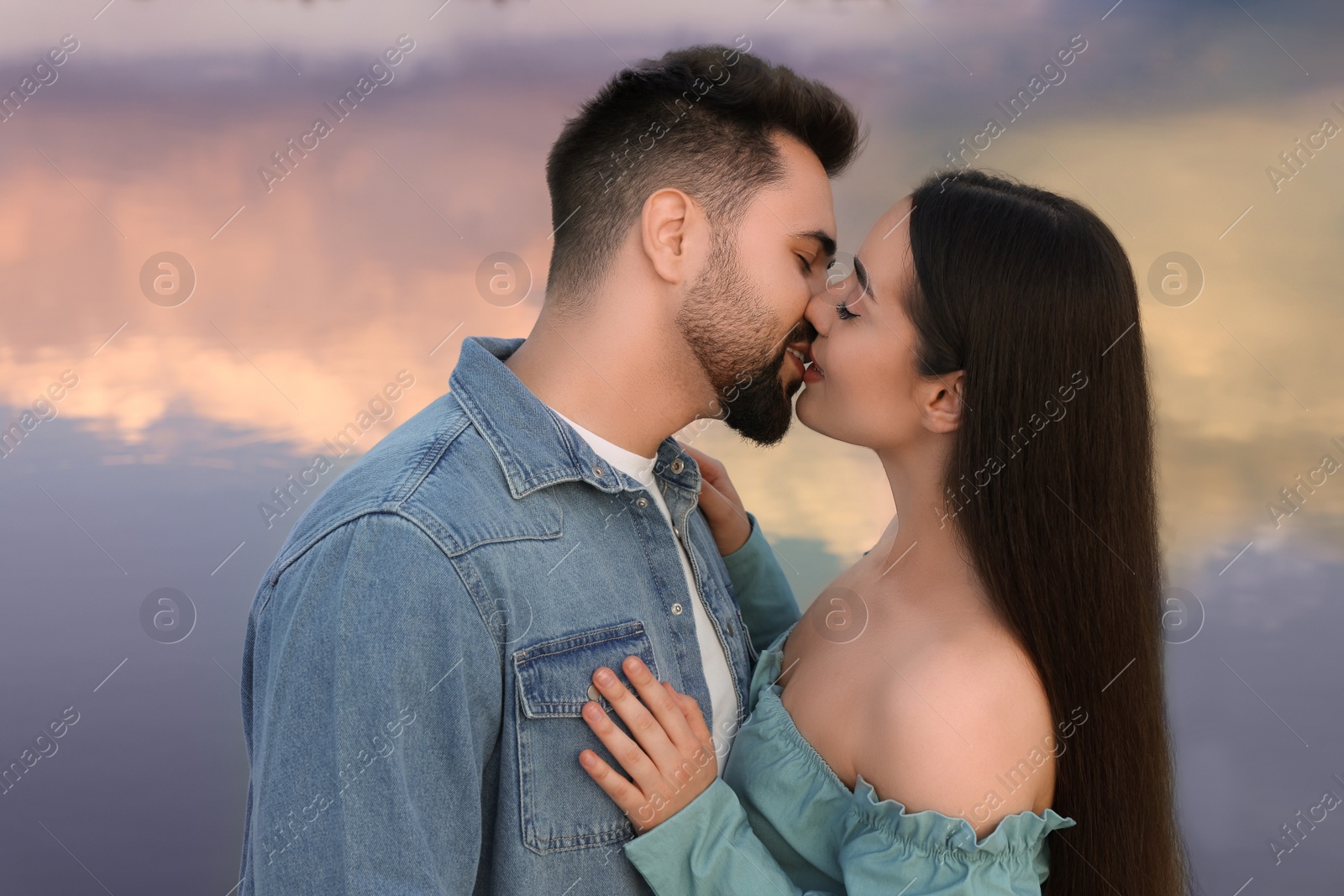 Photo of Romantic date. Beautiful couple kissing near lake