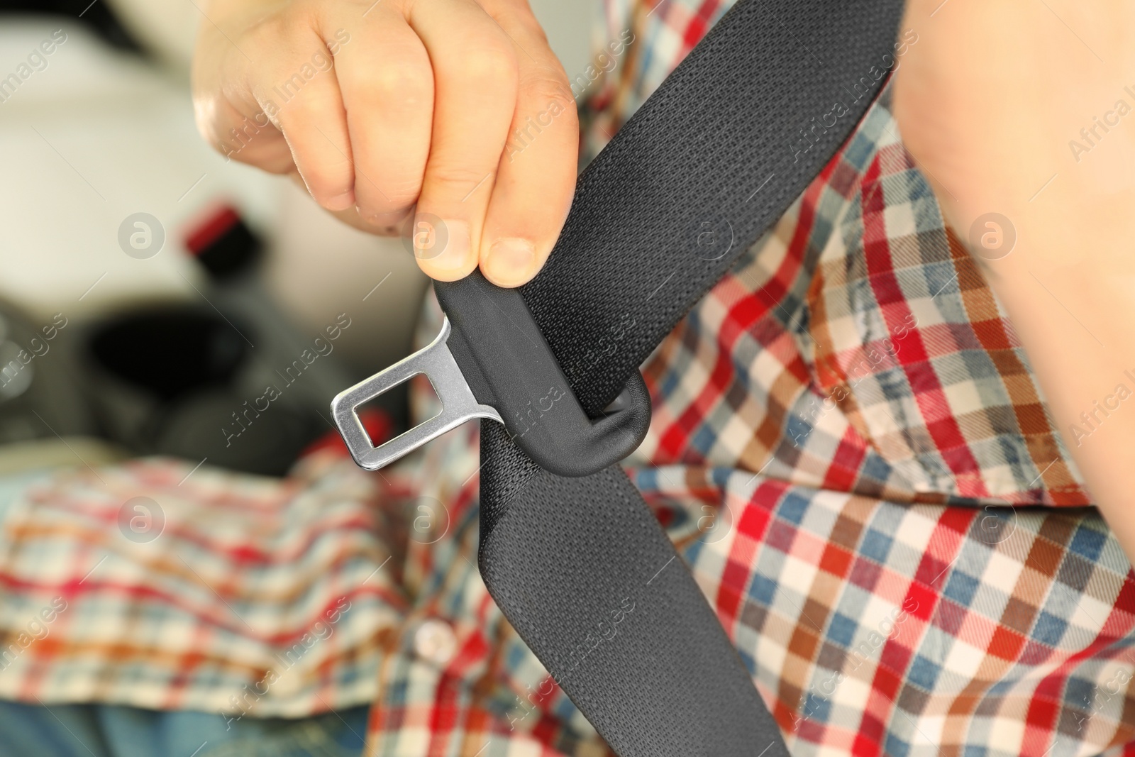 Photo of Male driver fastening safety belt in car, closeup