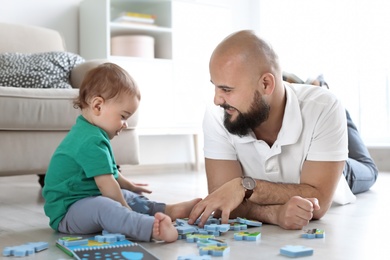 Photo of Dad and his little son playing together at home