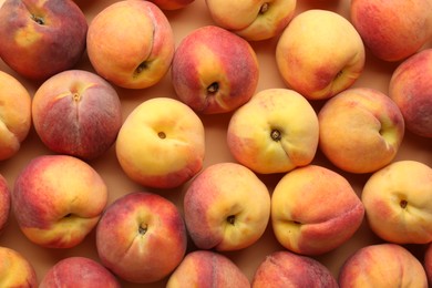 Fresh ripe peaches on beige background, flat lay