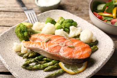 Photo of Healthy meal. Tasty grilled salmon with vegetables served on wooden table, closeup