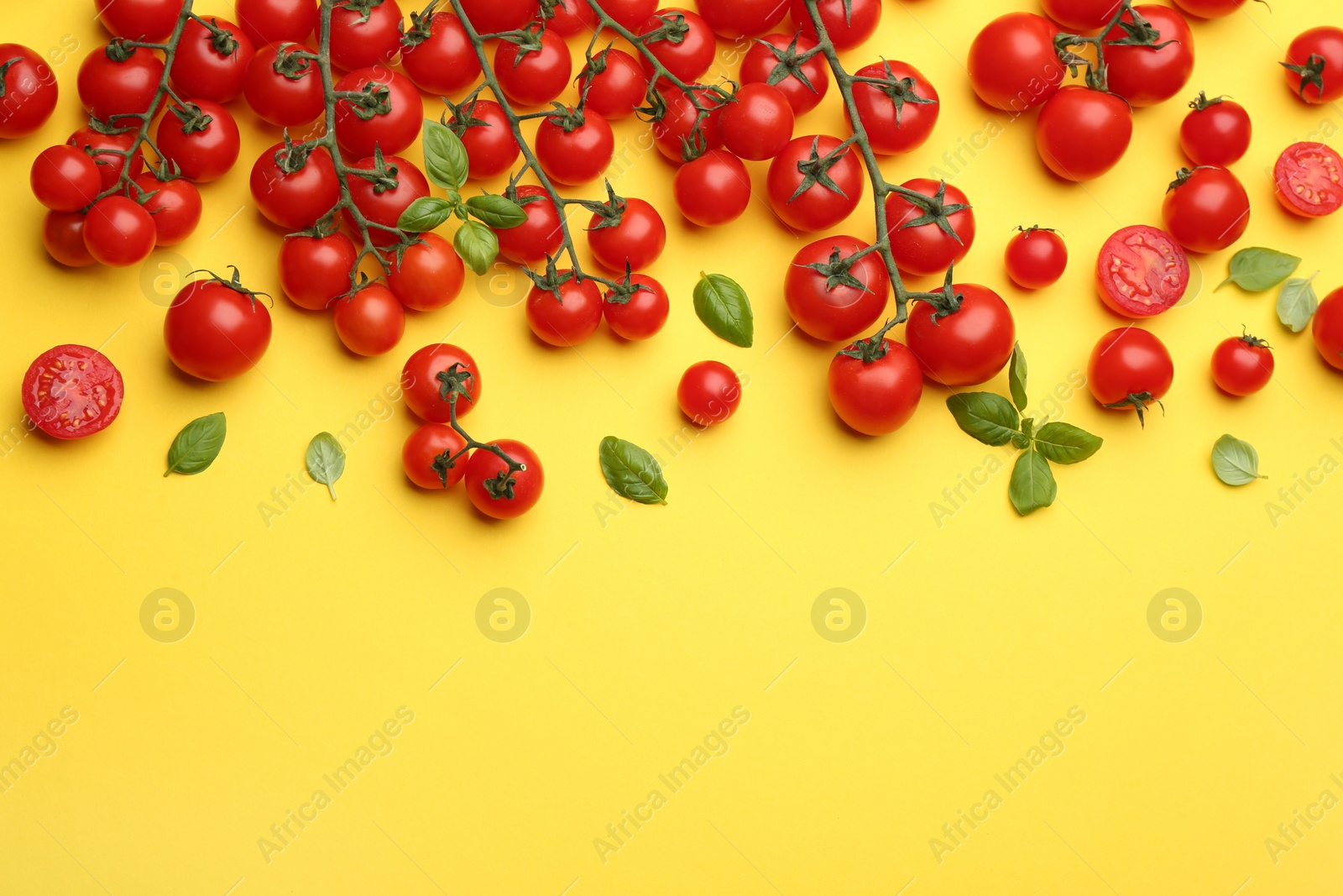 Photo of Fresh cherry tomatoes and basil leaves on yellow background, flat lay. Space for text