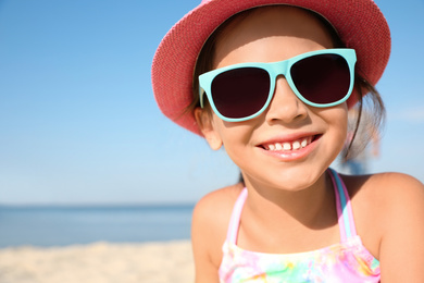 Photo of Cute little child at beach on sunny day