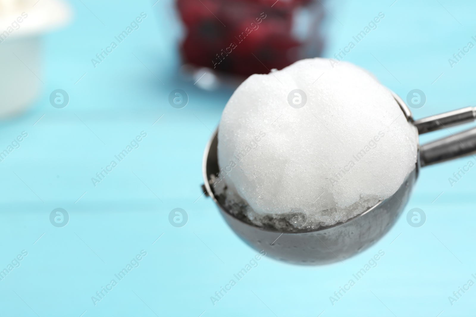 Photo of Scoop with snow ice cream ball against color background, closeup. Space for text