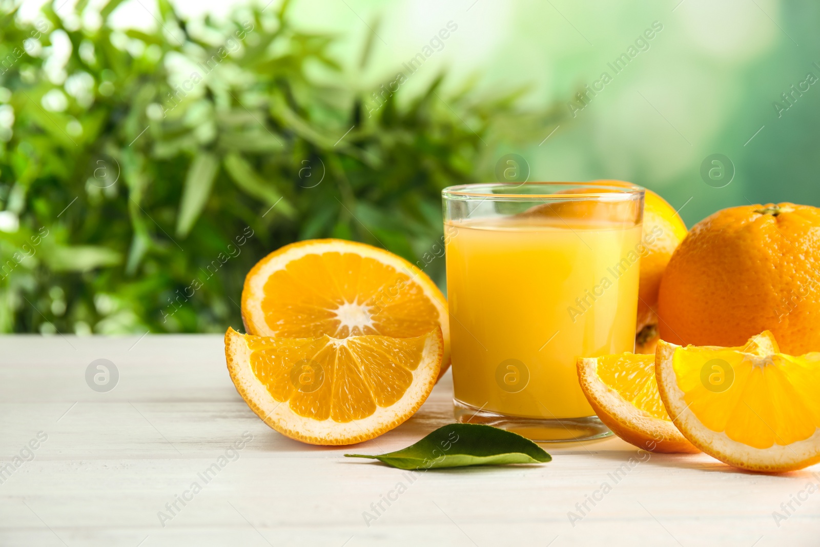 Photo of Composition with orange juice and fresh fruit on table, space for text