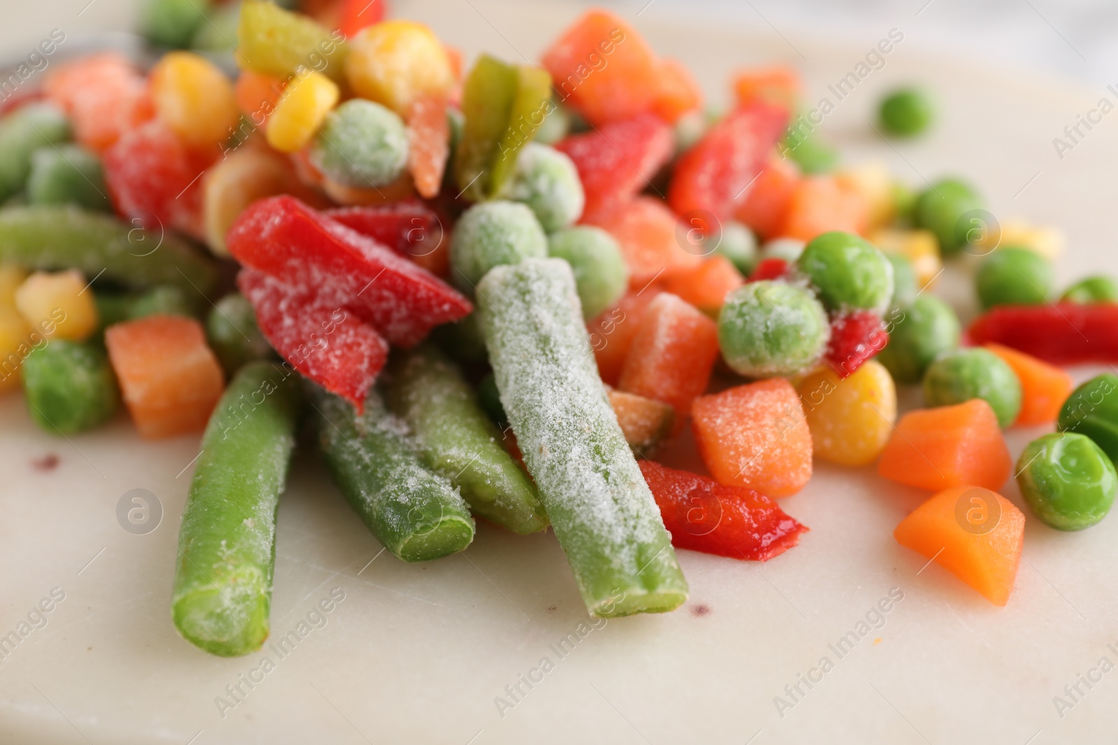 Photo of Mix of different frozen vegetables on board, closeup