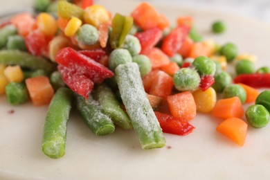 Mix of different frozen vegetables on board, closeup