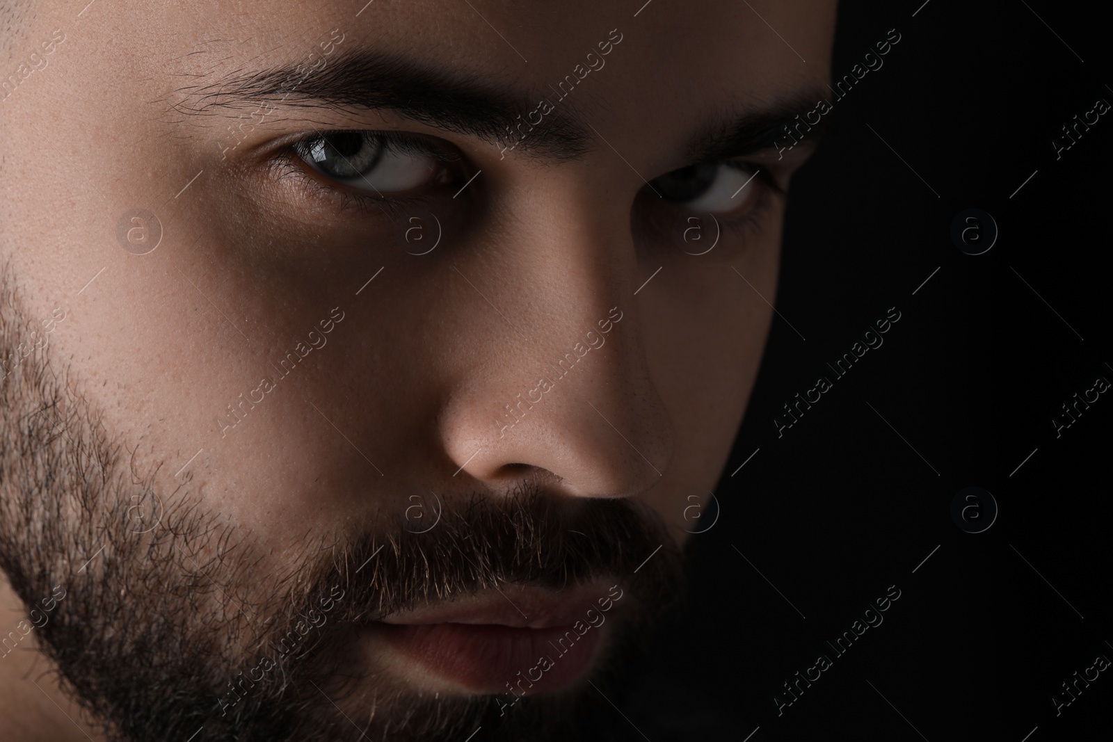 Photo of Evil eye. Man with scary eyes on black background