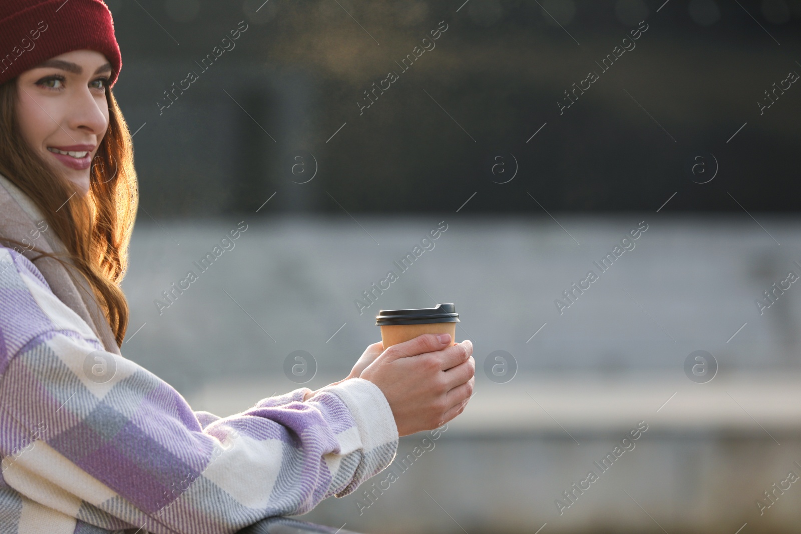 Photo of Woman holding paper coffee cup outdoors. Space for text