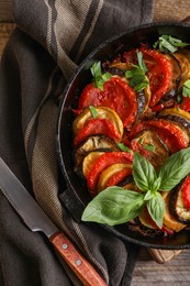 Delicious ratatouille and knife on table, flat lay