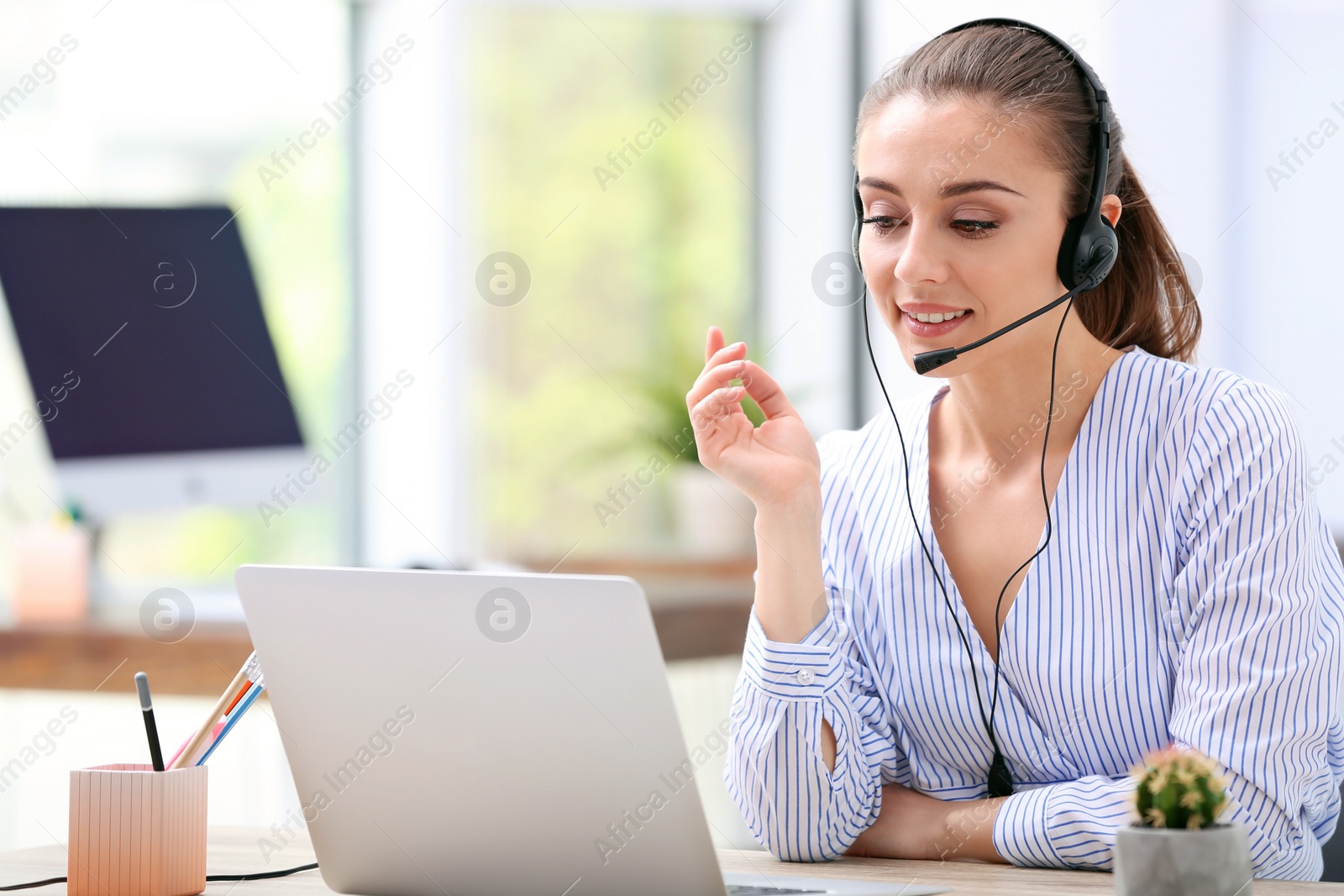 Photo of Female receptionist with headset at desk in office