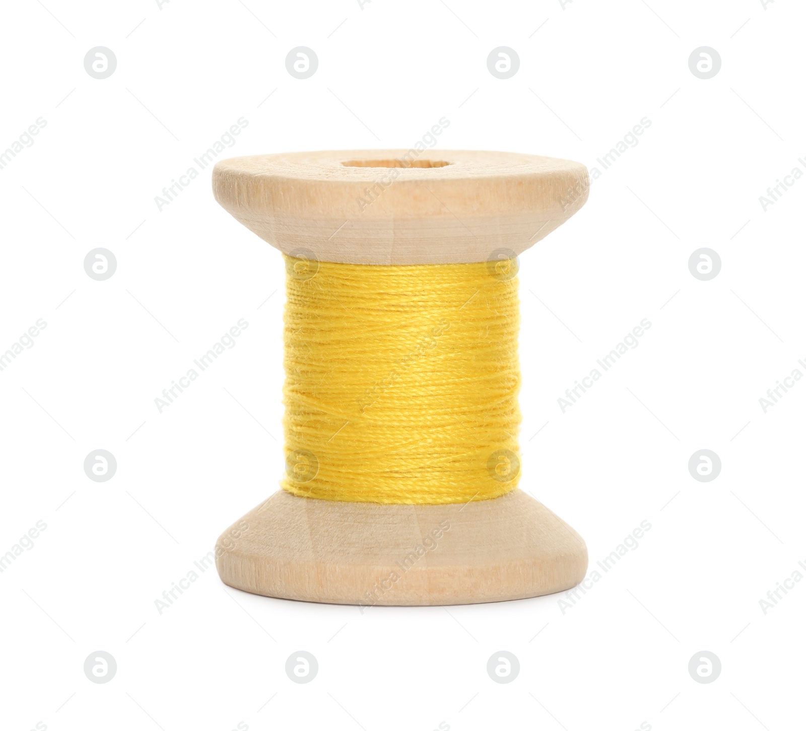 Photo of Wooden spool of yellow sewing thread isolated on white