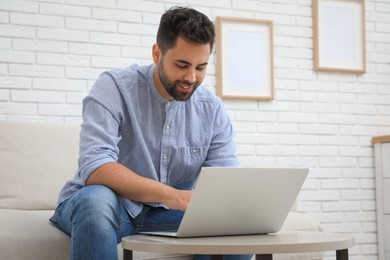 Photo of Man using laptop for online shopping at home