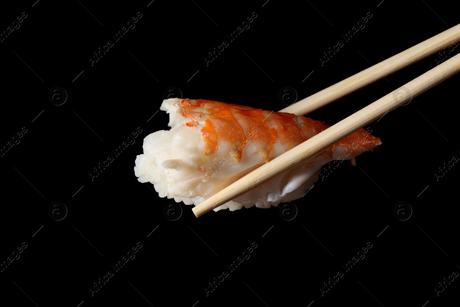 Photo of Chopsticks with delicious nigiri sushi on black background, closeup