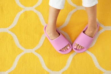 Photo of Woman in pink slippers indoors, closeup and top view. Space for text