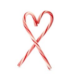 Photo of Heart shape made of tasty candy canes on white background. Festive treat