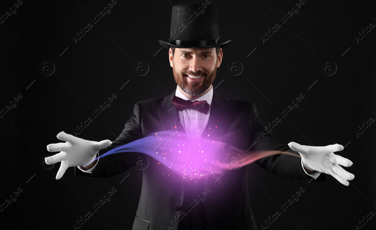 Image of Magic and sorcery. Magician with fantastic light on dark background