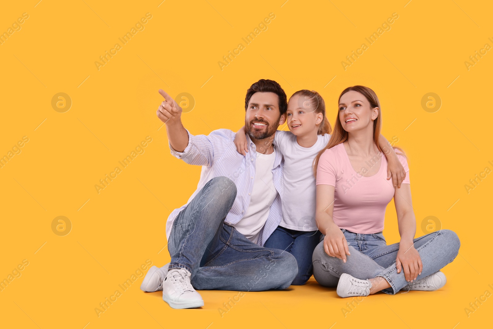 Photo of Happy family on orange background, space for text