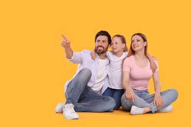 Happy family on orange background, space for text