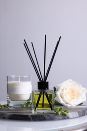 Composition with aromatic reed air freshener on glass table