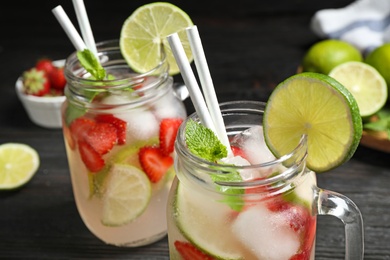 Photo of Mason jars with delicious refreshing drink table, closeup