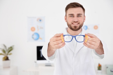 Photo of Young ophthalmologist with eyeglasses in clinic