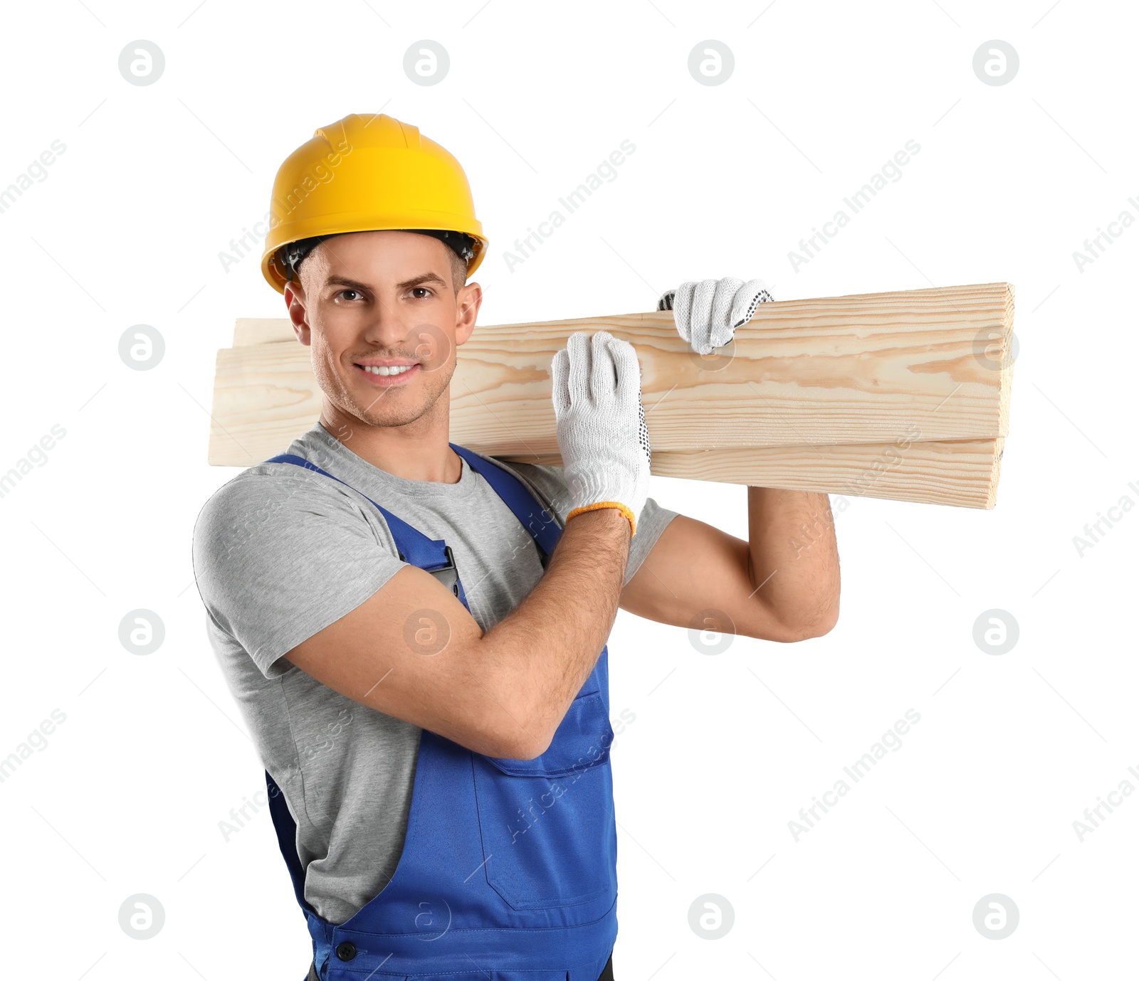 Photo of Handsome carpenter with wooden planks on light background