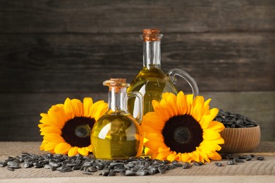 Sunflower cooking oil, seeds and yellow flowers on wooden table