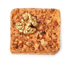 Photo of Piece of layered honey cake with walnuts on white background, top view