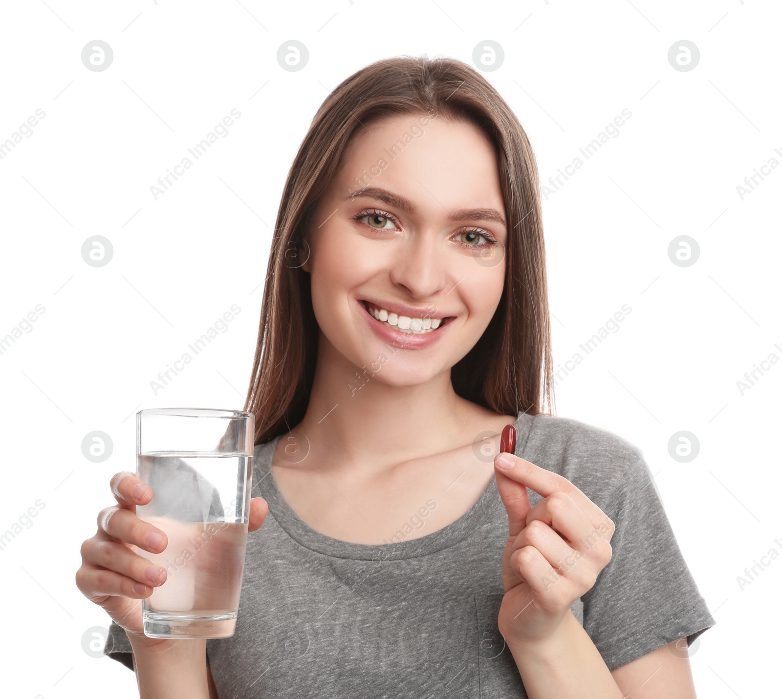 Photo of Young woman with vitamin pill and glass of water on white background