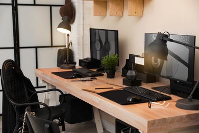 Photo of Stylish workplace interior with computers on table