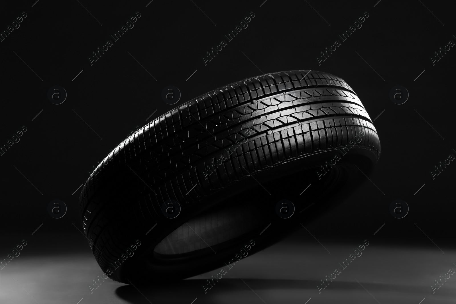 Photo of New car tire on black background