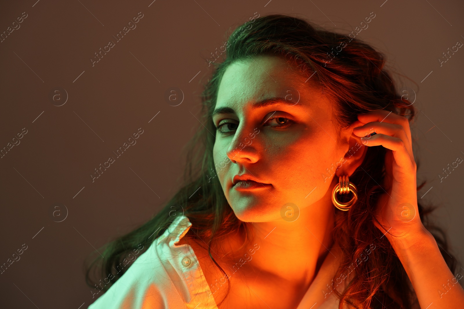 Photo of Portrait of beautiful young woman on color background with neon lights