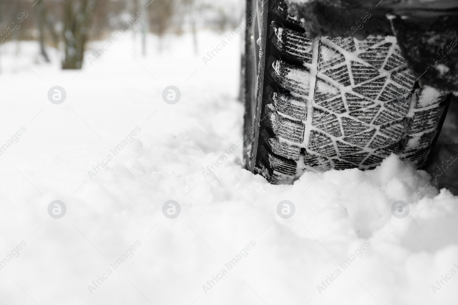 Photo of Snowy country road with car on winter day, closeup. Space for text