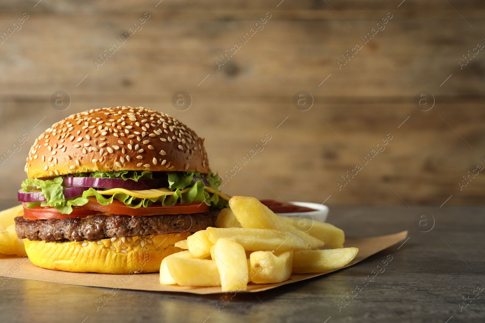 Burger with delicious patty and french fries on table, space for text Photo of Burger with delicious patty and french fries on table, space for text