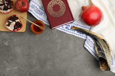 Flat lay composition with Rosh Hashanah holiday symbols on grey table. Space for text