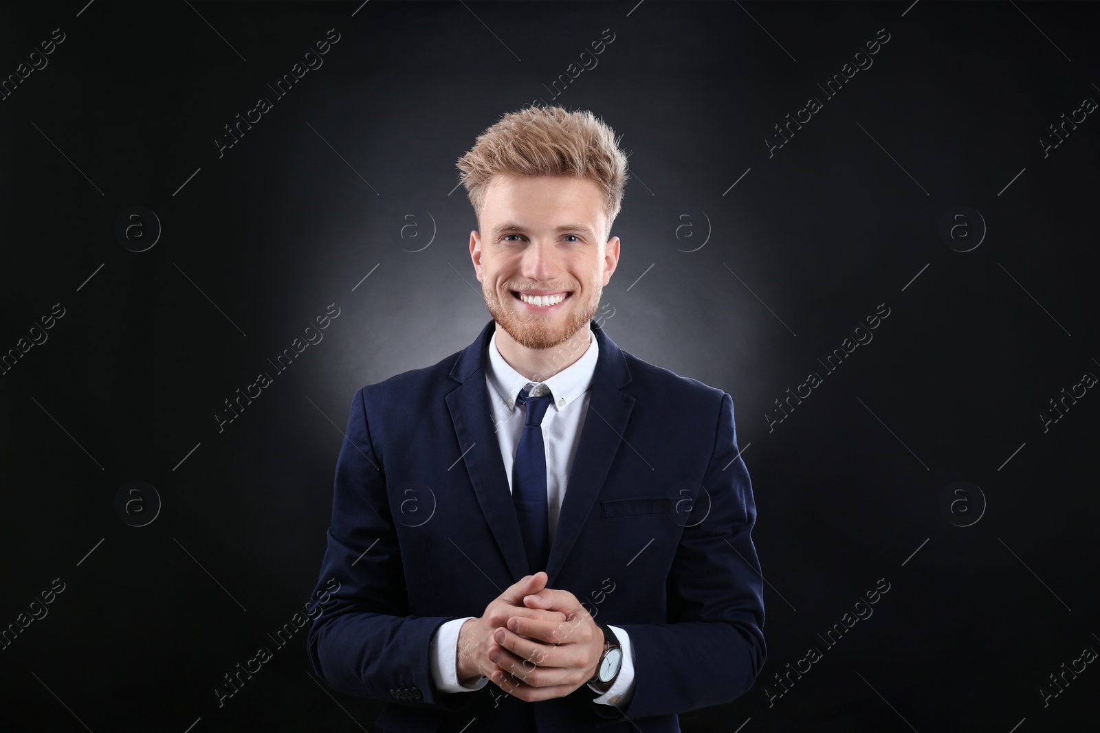 Photo of Portrait of handsome young businessman on dark background