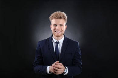 Photo of Portrait of handsome young businessman on dark background