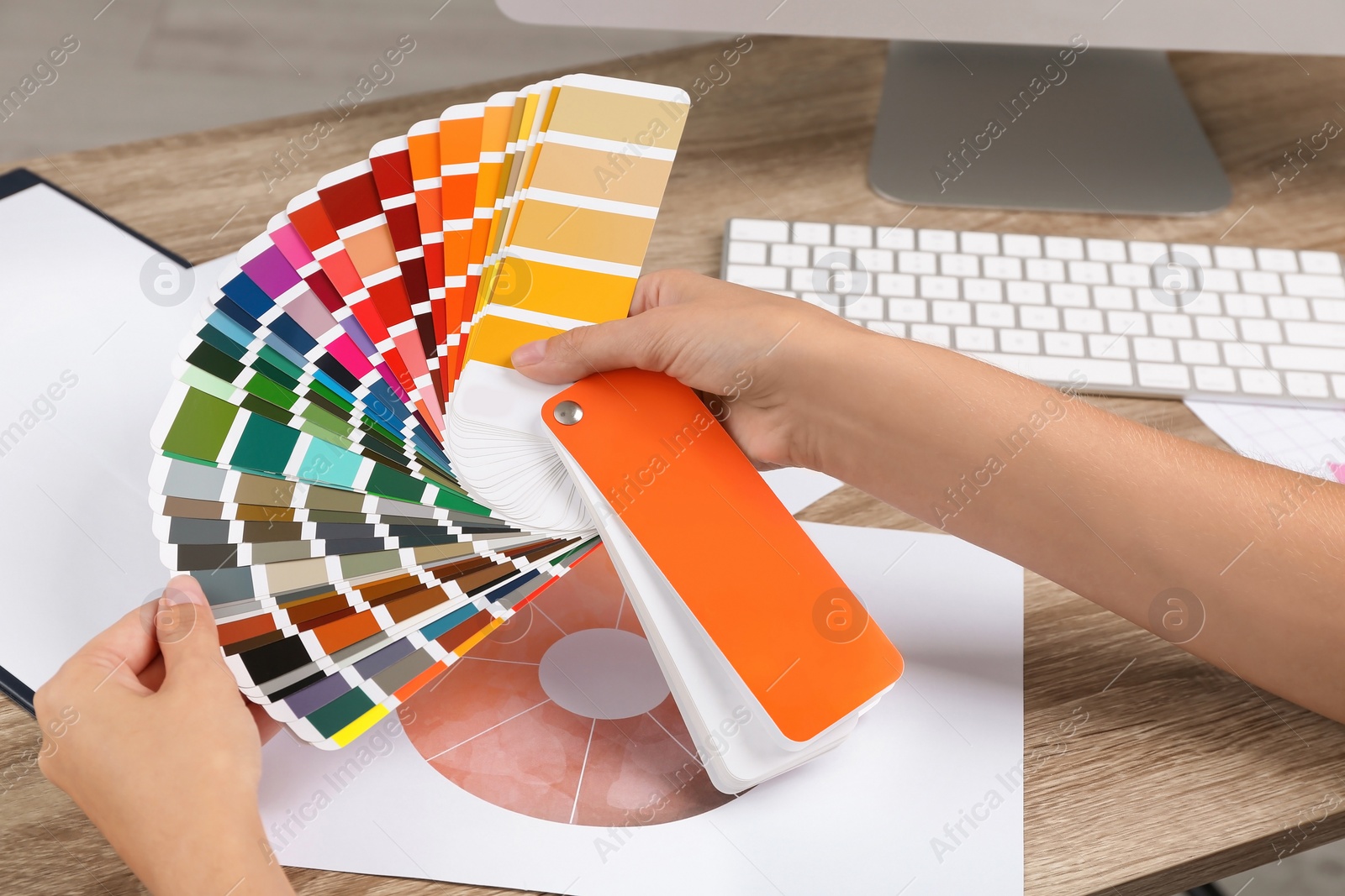 Photo of Woman with color palette samples at table, closeup