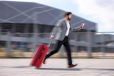 Image of Being late. Businessman with suitcase and ticket running at station. Motion blur effect