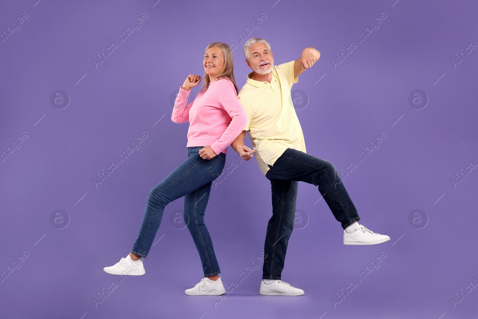 Photo of Senior couple dancing together on purple background